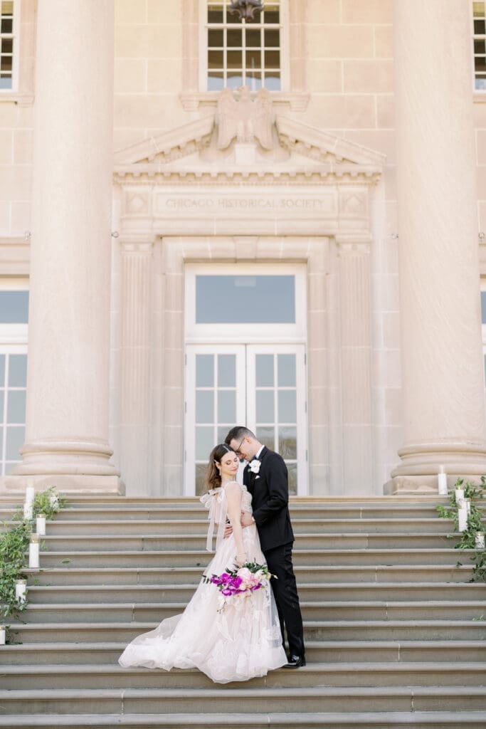bride and groom kissing on stairs during chicago history museum wedding