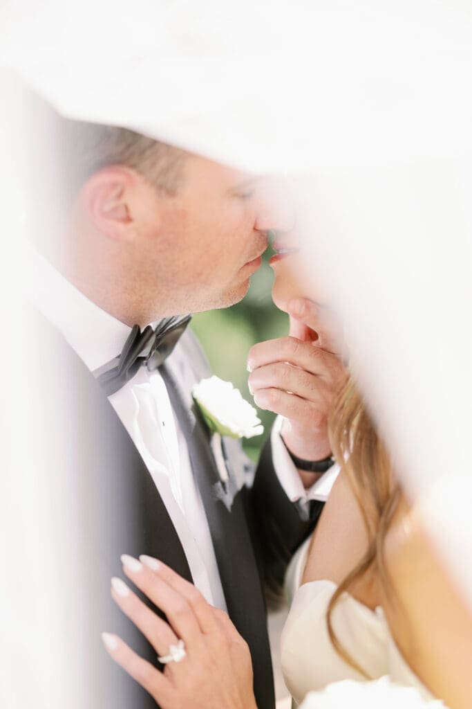 bride and groom kissing under veil at four seasons austin wedding