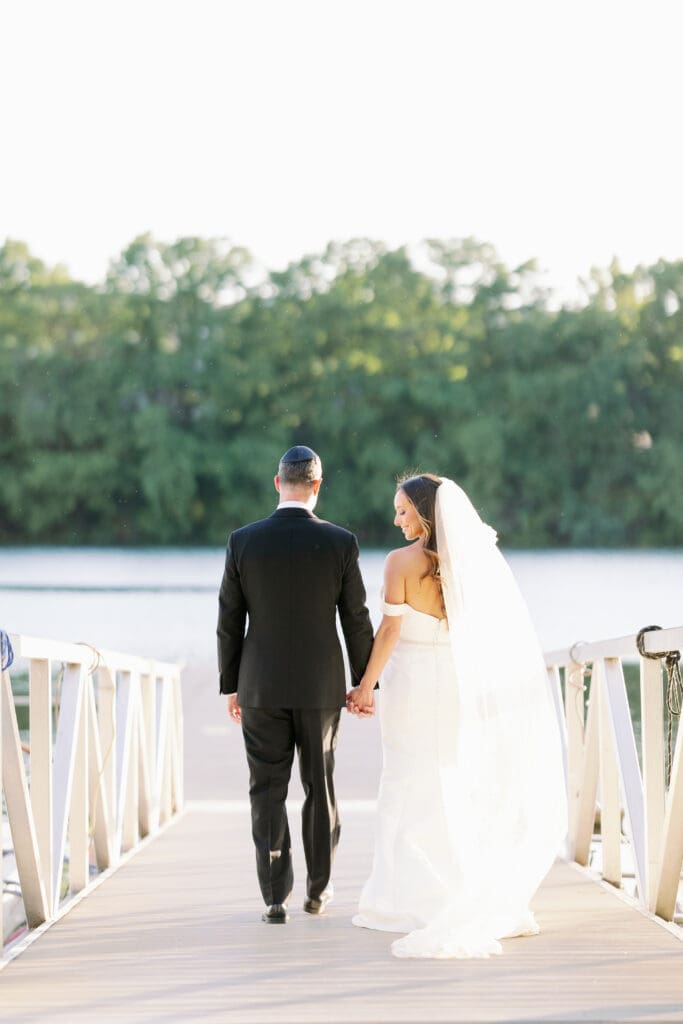 bride and groom walking along river at four seasons austin wedding