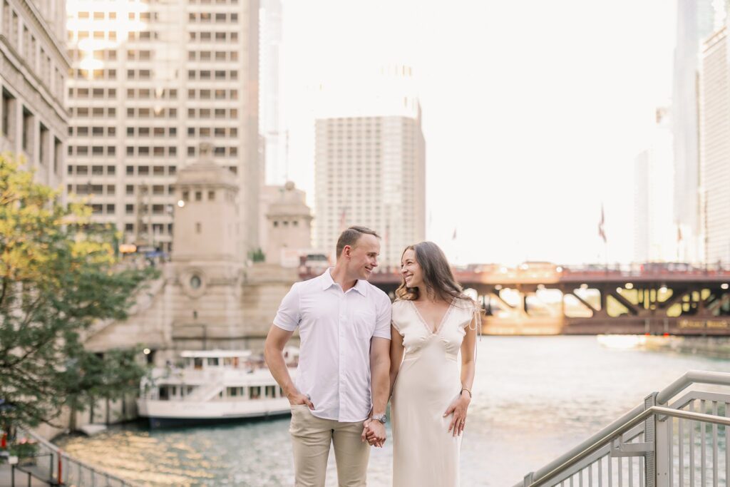bride and groom posing at chicago riverwalk engagement photos