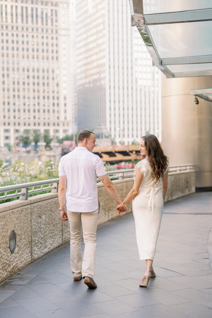 bride and groom posing at chicago riverwalk engagement photos