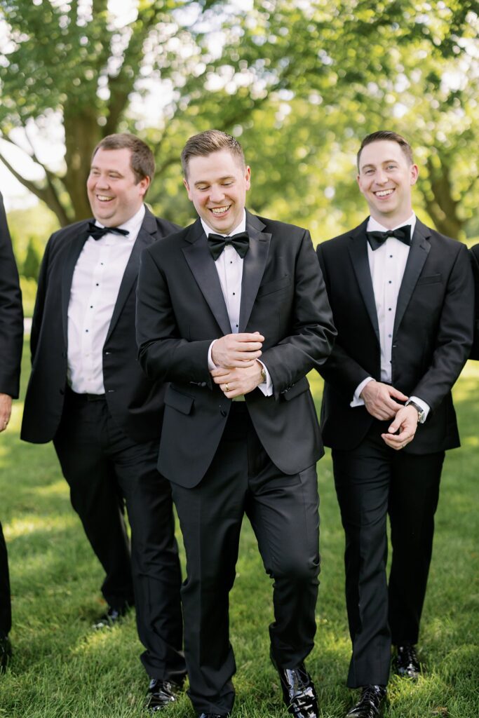 groom walking with friends at stonebridge country club wedding