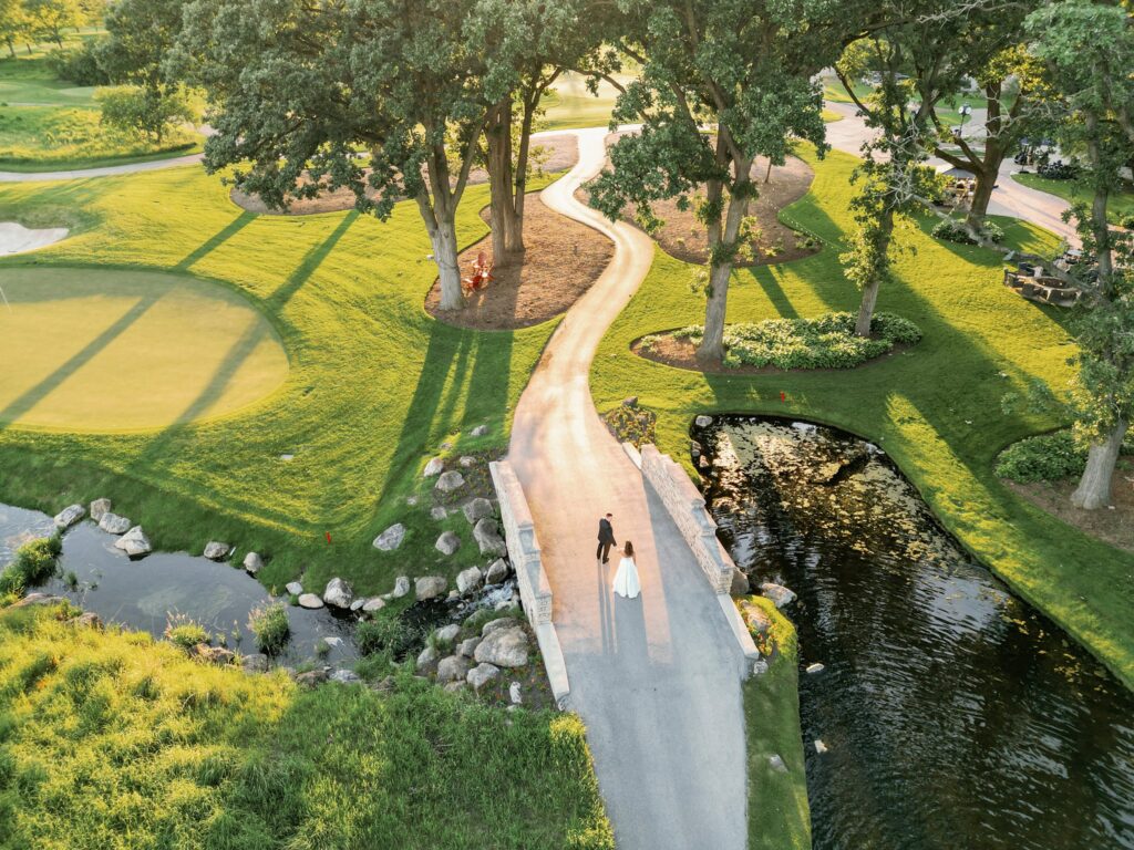 drone photo of bride and groom walking at stonebridge country club wedding