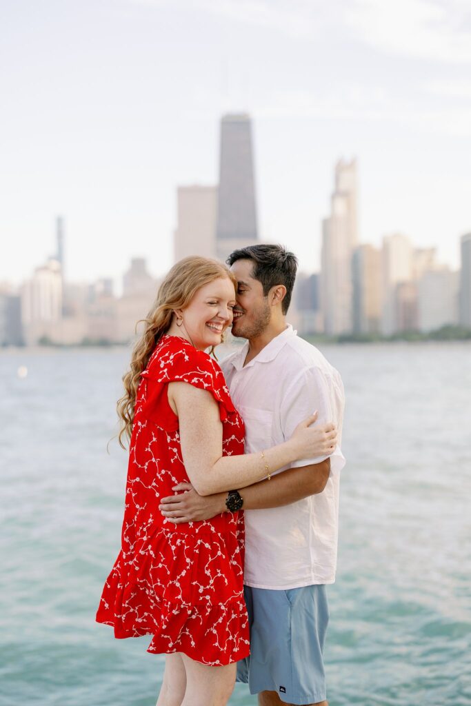 Engaged Couple pose at Lake Michigan on beach in Chicago