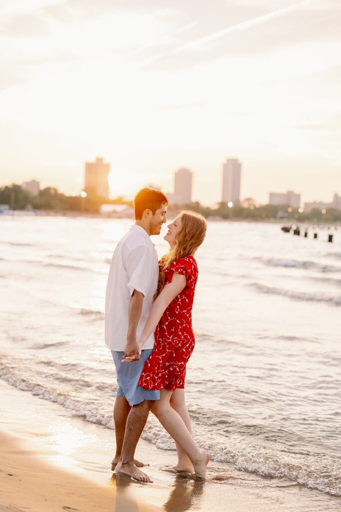 Engaged Couple pose at Lake Michigan on beach in Chicago