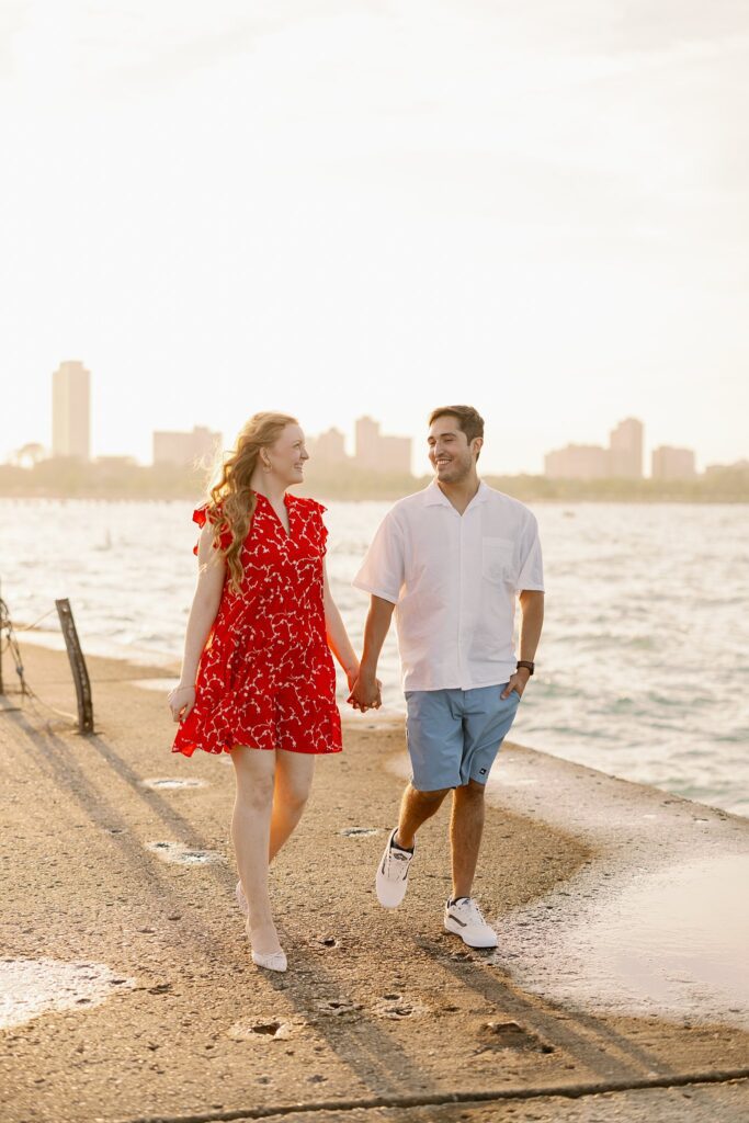 Engaged Couple pose at Lake Michigan on beach in Chicago