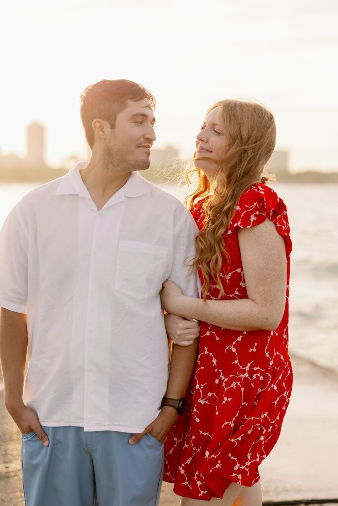 Engaged Couple pose at Lake Michigan on beach in Chicago