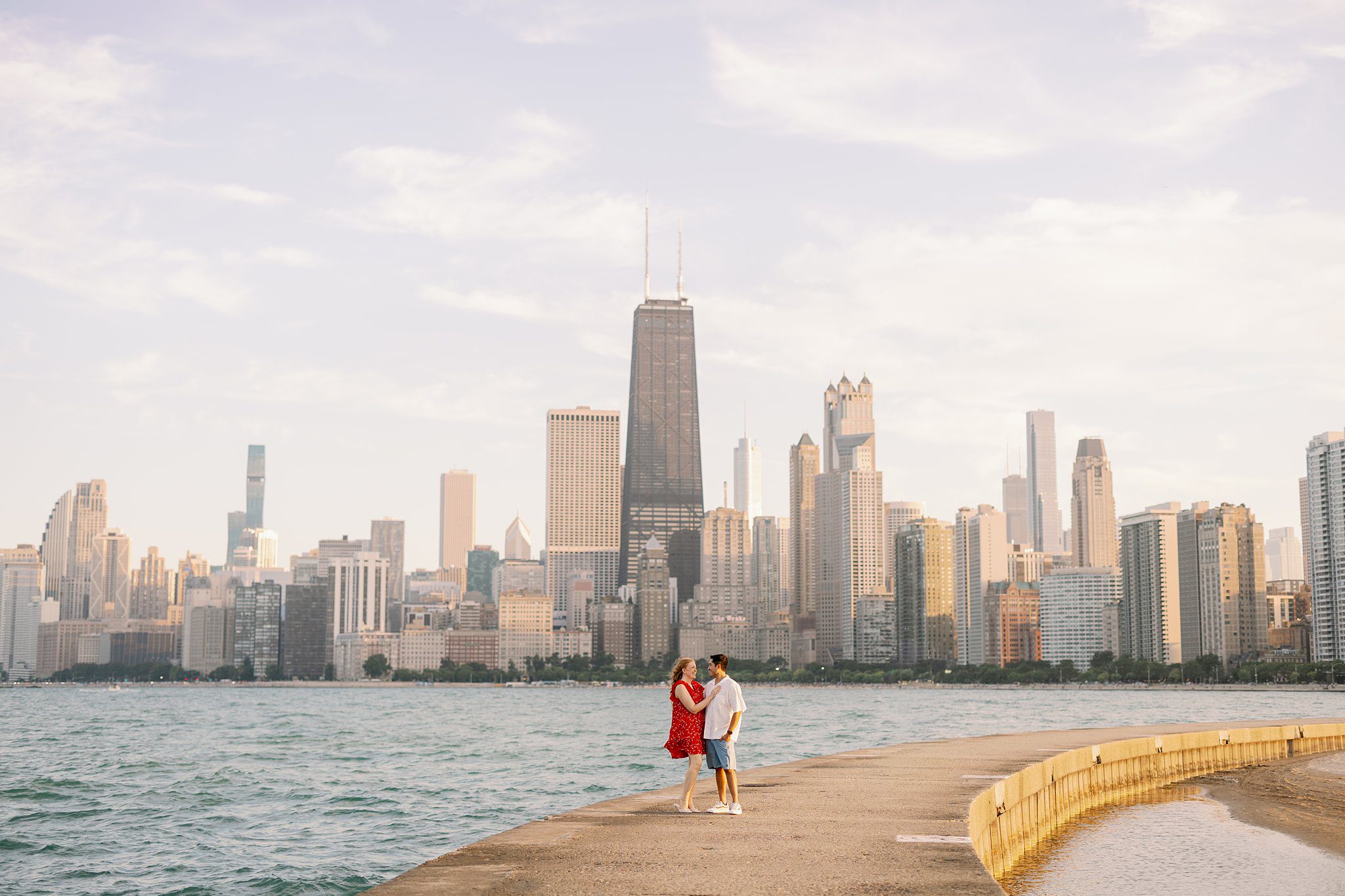 Engaged Couple pose at Lake Michigan on beach in Chicago