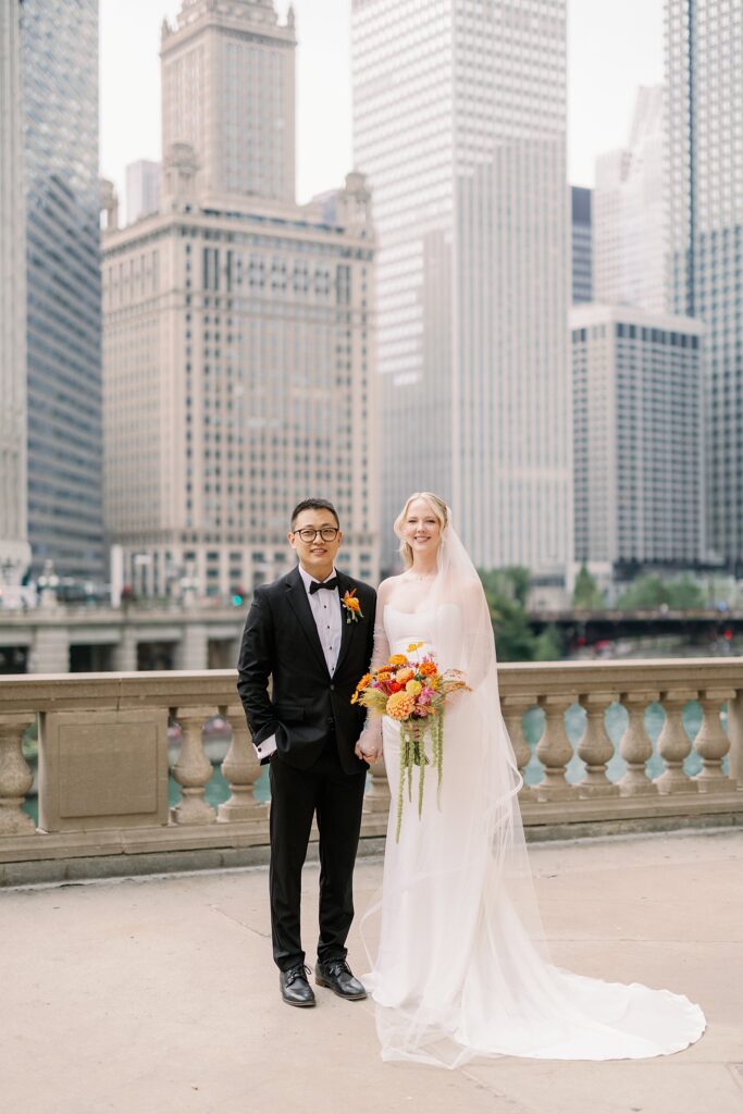 bride and groom pose at Wrigley Building downtown Chicago
