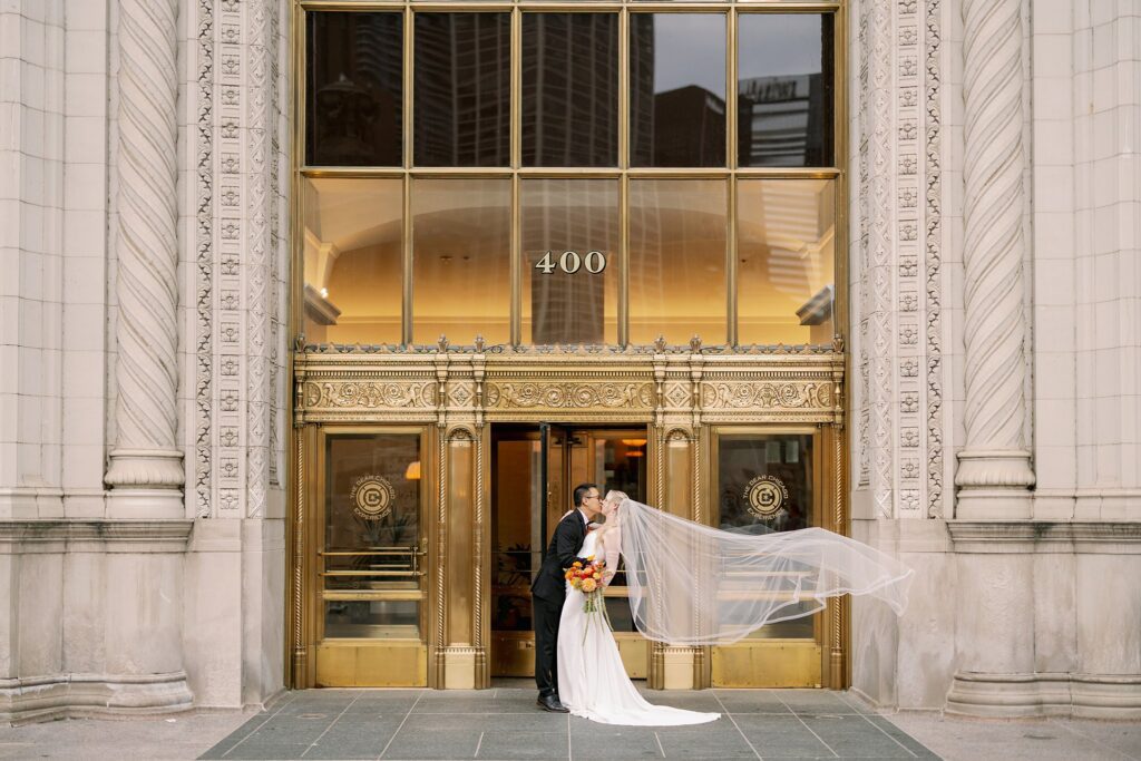 bride and groom kiss at wrigley building downtown chicago