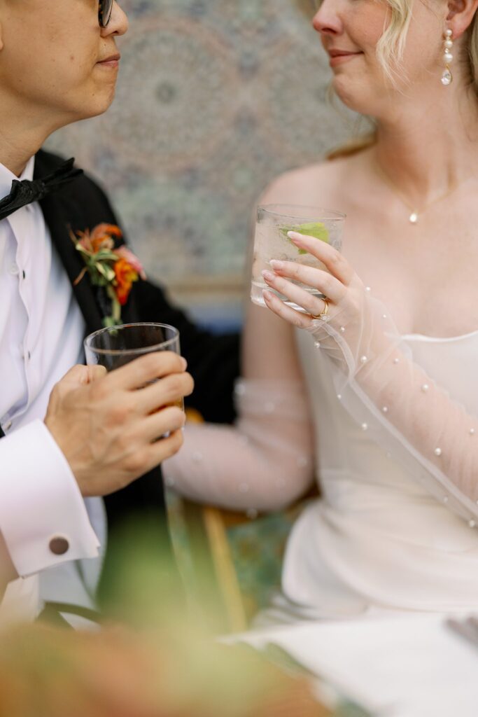 bride and groom cheers at cocktail hour at their Garfield Park Conservatory Wedding